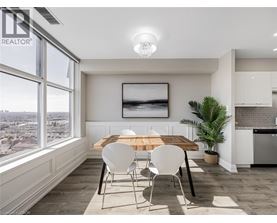 A dining room with a wooden table and white chairs.