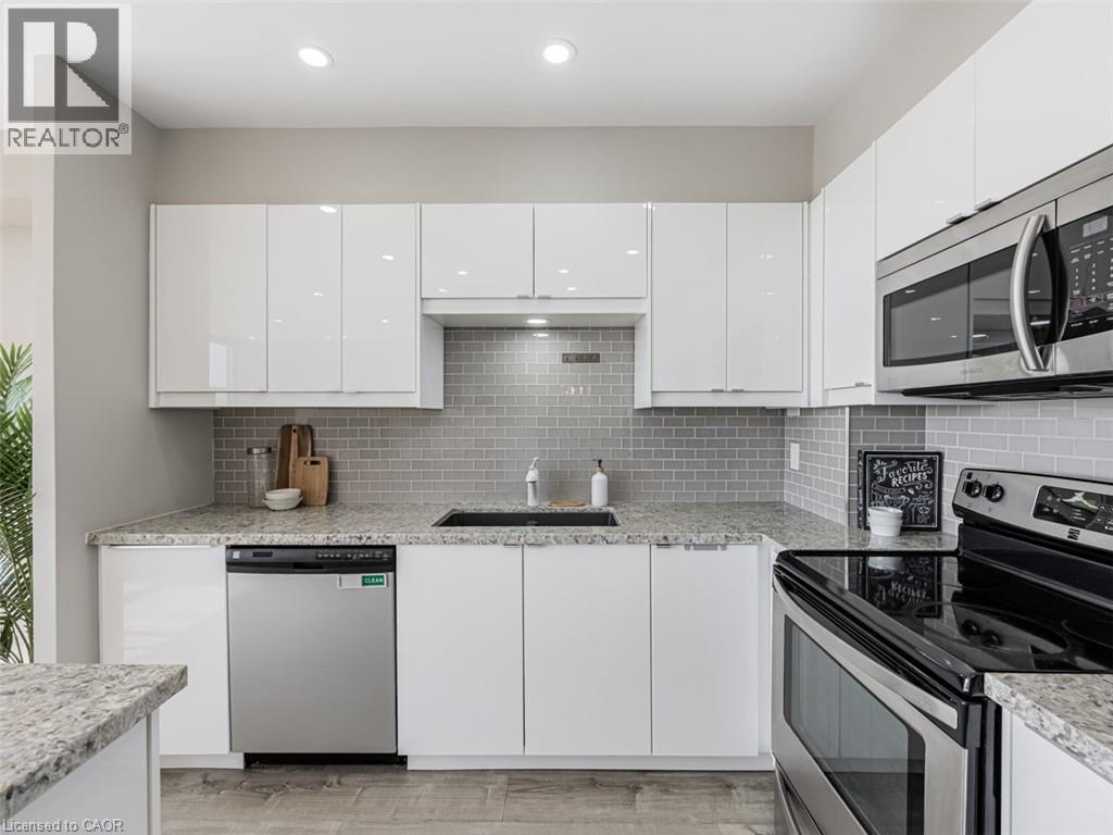 A modern kitchen with white cabinets and stainless steel appliances.