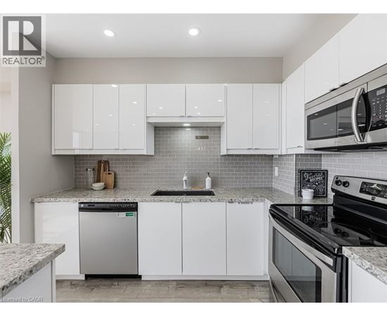 A modern kitchen with white cabinets and stainless steel appliances.