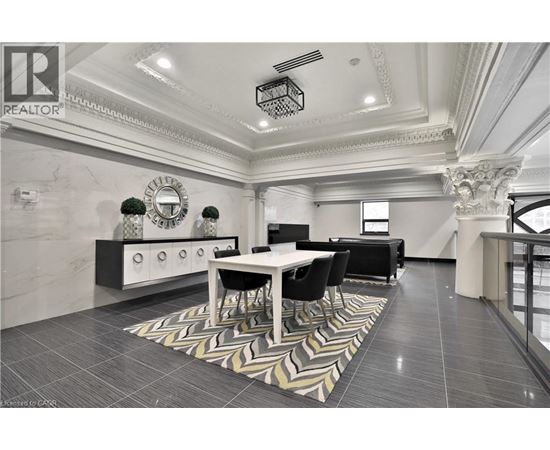 A well-lit, spacious dining area with a marble floor and a large table surrounded by chairs.