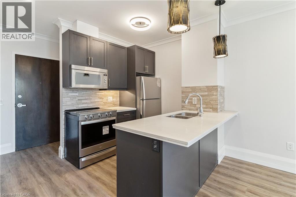A modern kitchen with dark wood cabinets and stainless steel appliances.