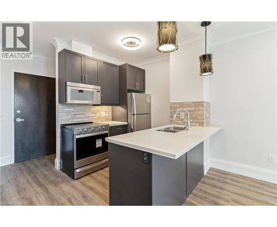 A modern kitchen with dark wood cabinets and stainless steel appliances.