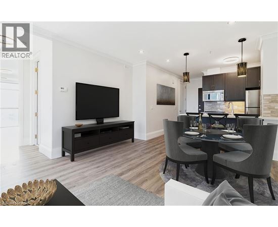 A modern living room with a black television and grey chairs.