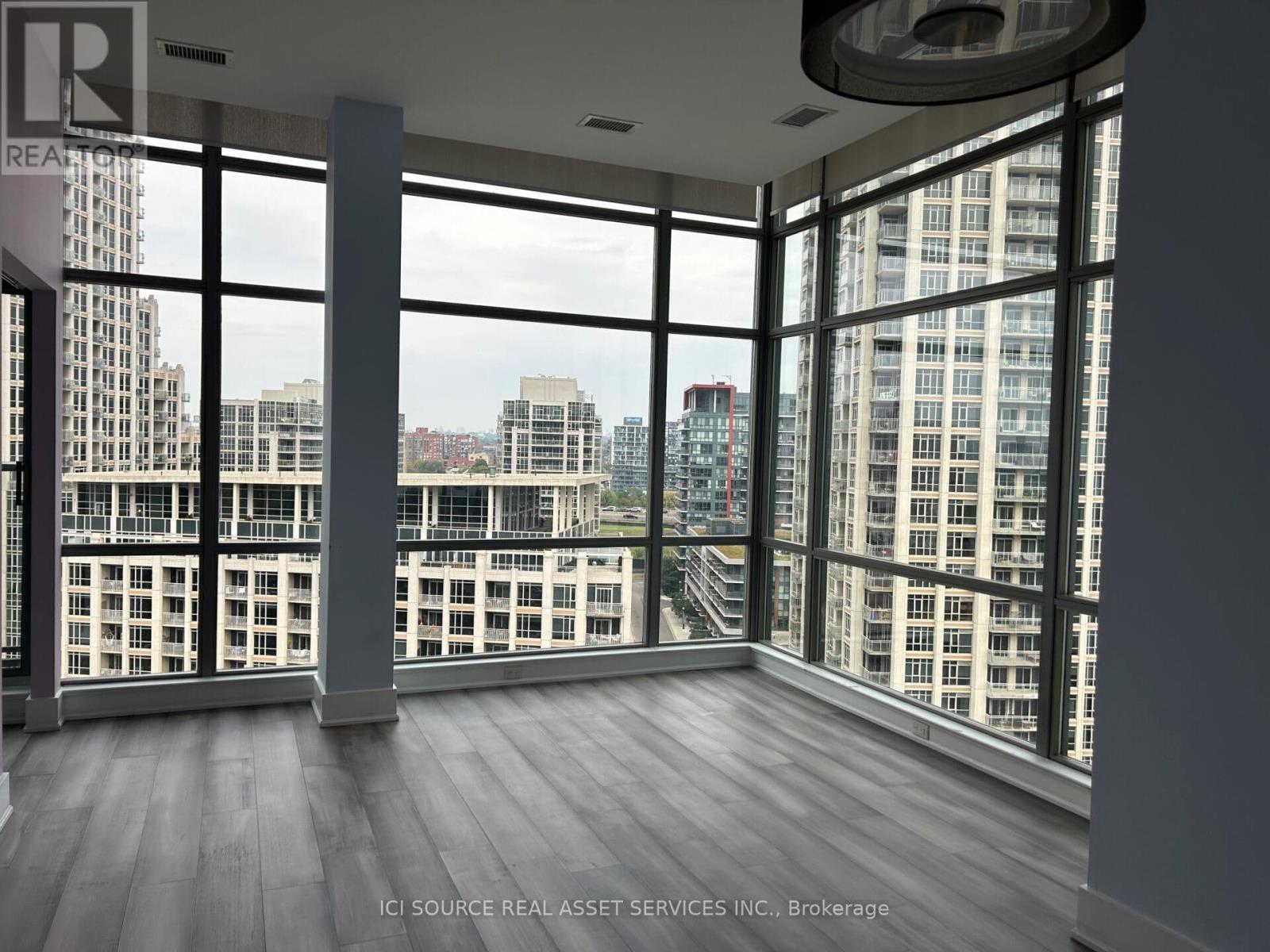 A room with large windows overlooking a cityscape.