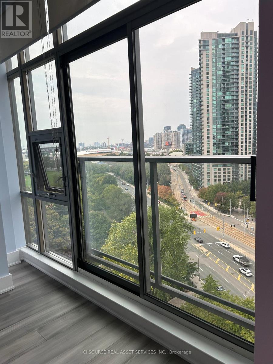 A window with a view of a city street and buildings outside.
