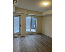 A room with a door, a window and a wooden floor.