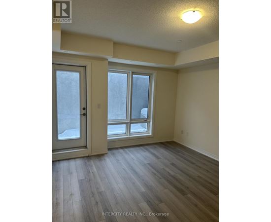 A room with a door, a window and a wooden floor.