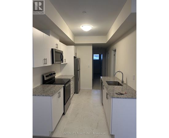 A kitchen with white cabinets and granite countertops.