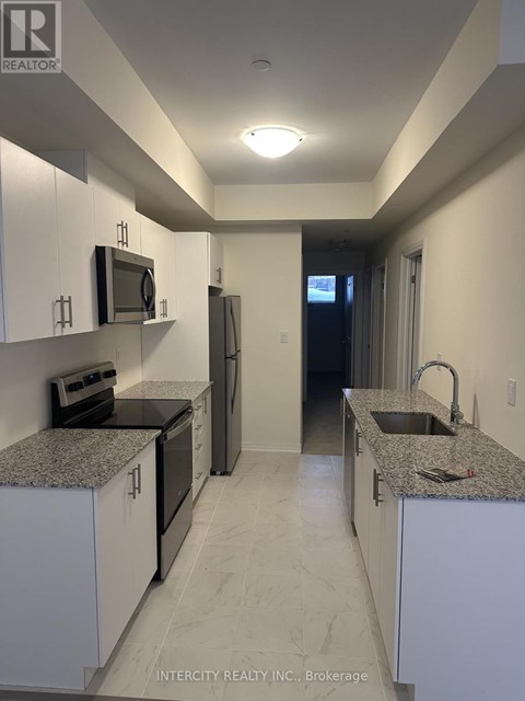 A kitchen with white cabinets and granite countertops.