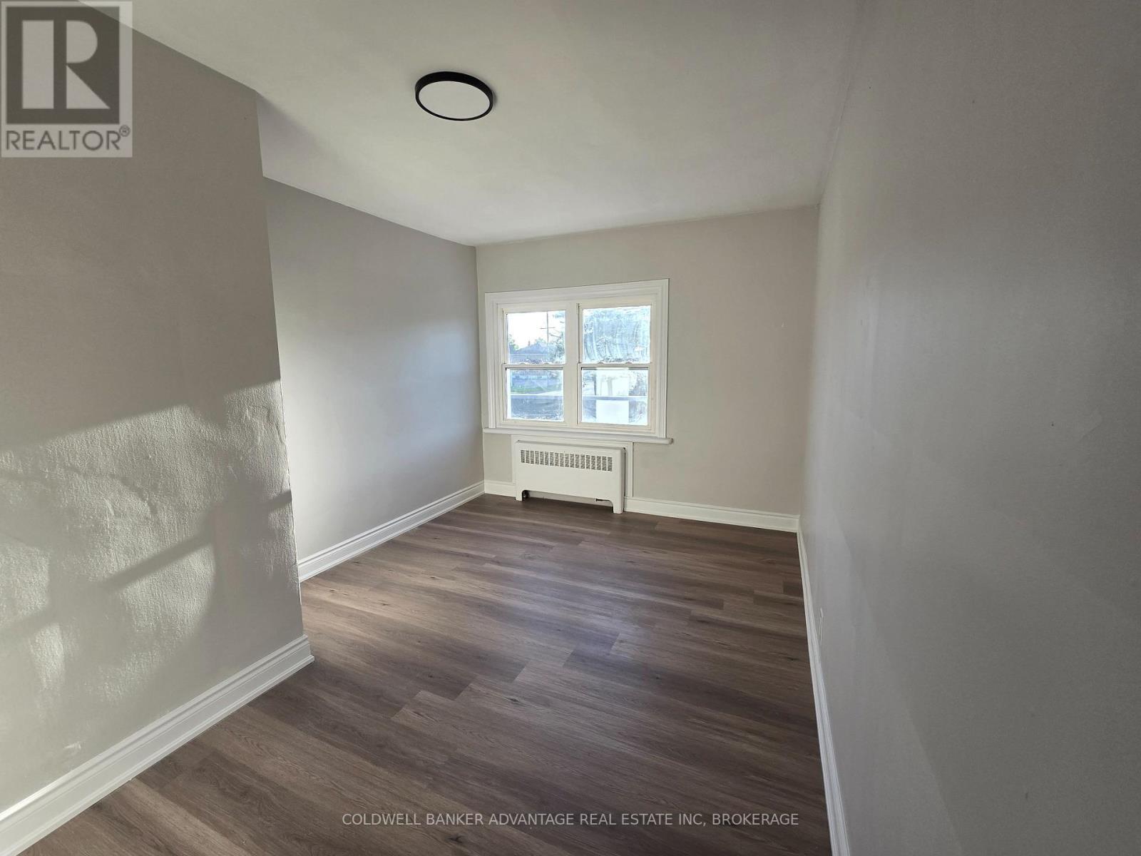 A room with a window and a radiator on the wall.