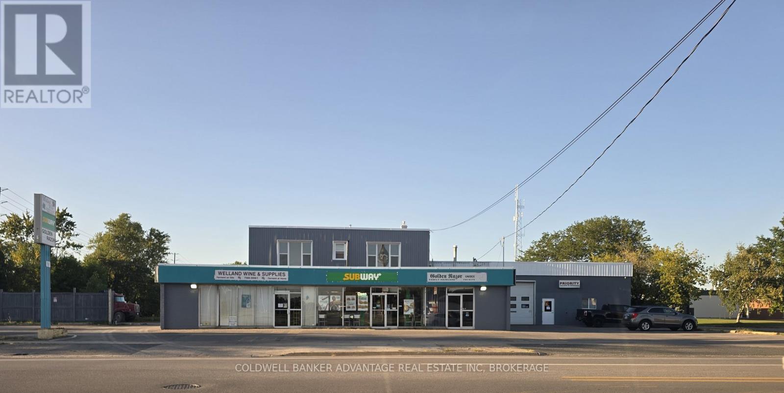 A real estate company named Coldwell Banker is located in a building with a green awning.