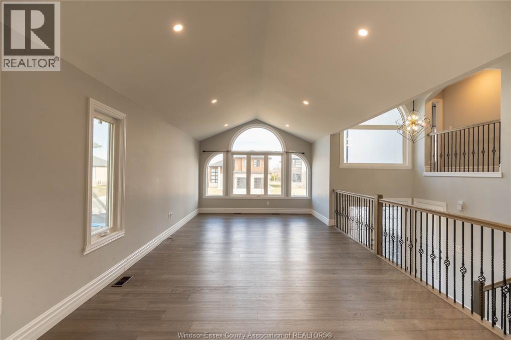 A spacious room with a large window and a balcony with a railing.