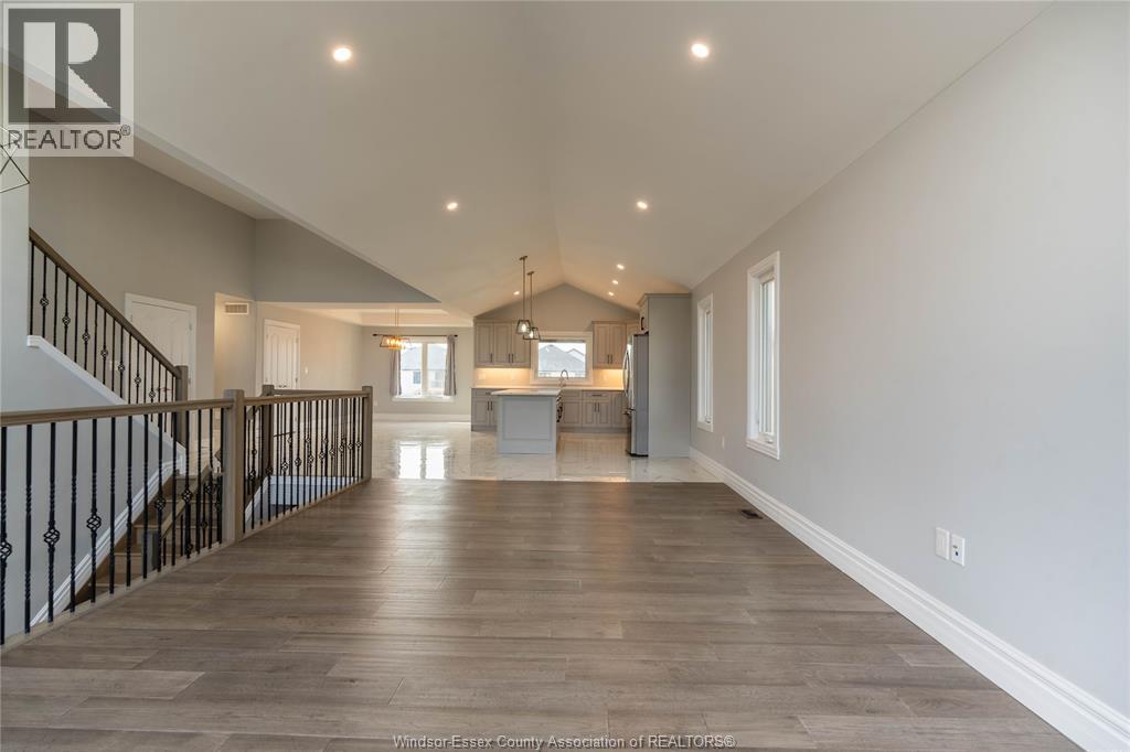 A spacious living room with a staircase on the left side.