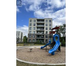 A playground with a blue slide and a building in the background.