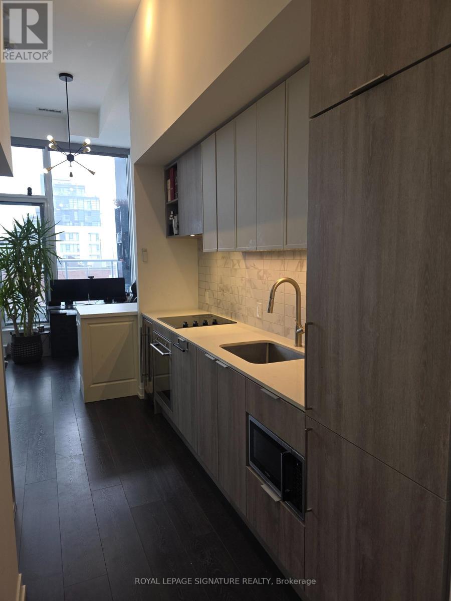 A modern kitchen with wooden cabinets and a marble backsplash.