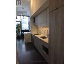 A modern kitchen with wooden cabinets and a marble backsplash.