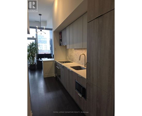 A modern kitchen with wooden cabinets and a marble backsplash.