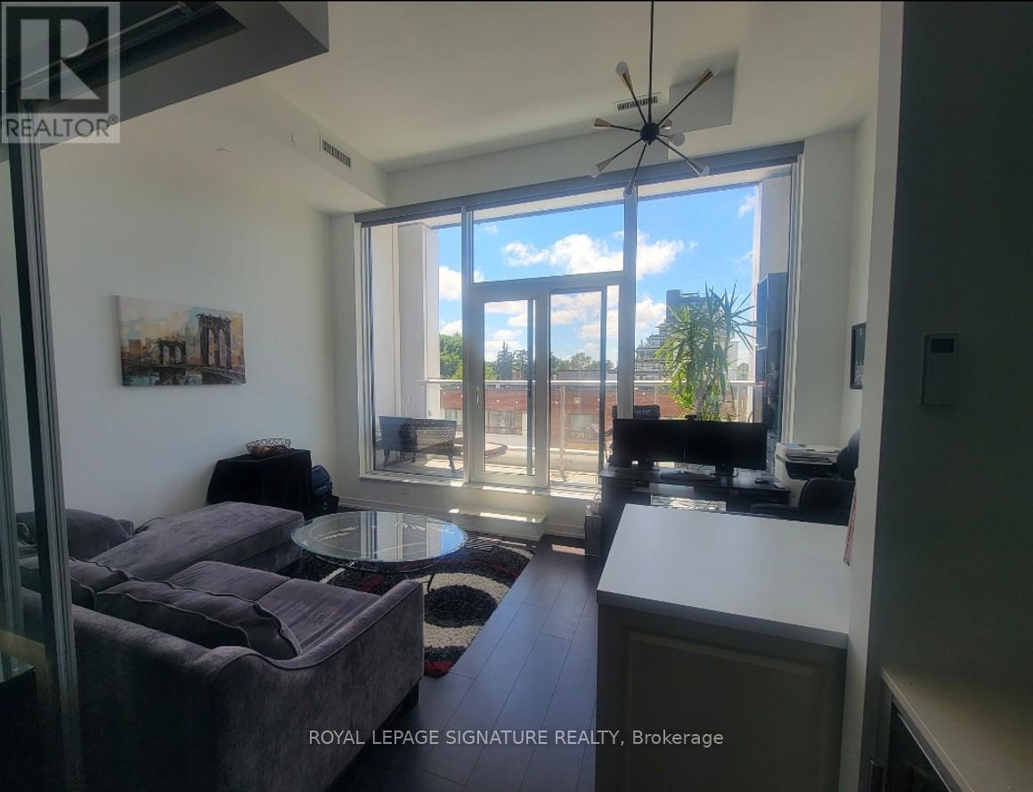 A living room with a grey couch and a table in front of a large window.