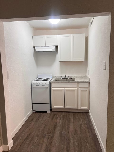 A small kitchen with a white dishwasher and a white oven.