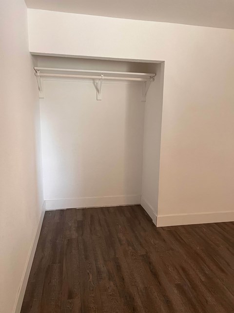 A room with a white wall and a brown floor.