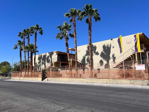 A building with palm trees in front of it.