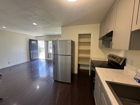A kitchen with a refrigerator, oven, and a dishwasher.
