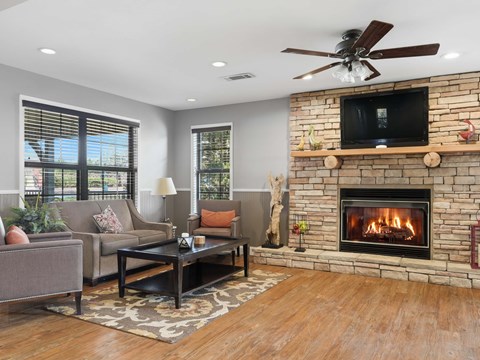 A living room with a fireplace and a television on the wall.