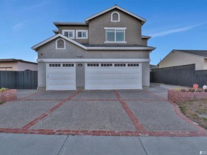 A house with a grey roof and two garages.