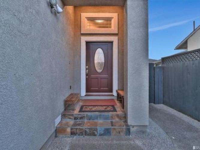 A brown door is at the end of a stone staircase.