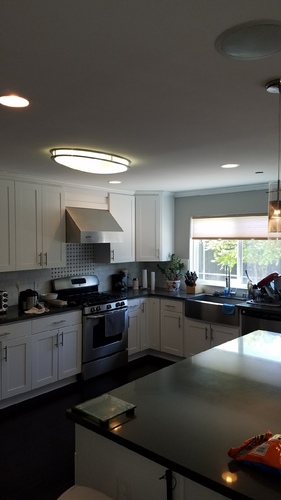A kitchen with black countertops and white cabinets.