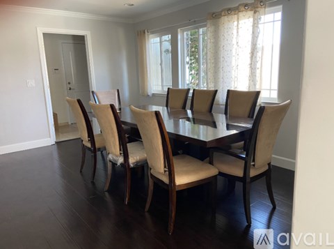 A dining room with a table and chairs.