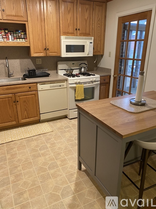 A kitchen with wooden cabinets and a white microwave above the stove.