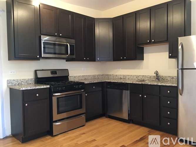 A kitchen with black cabinets and stainless steel appliances.
