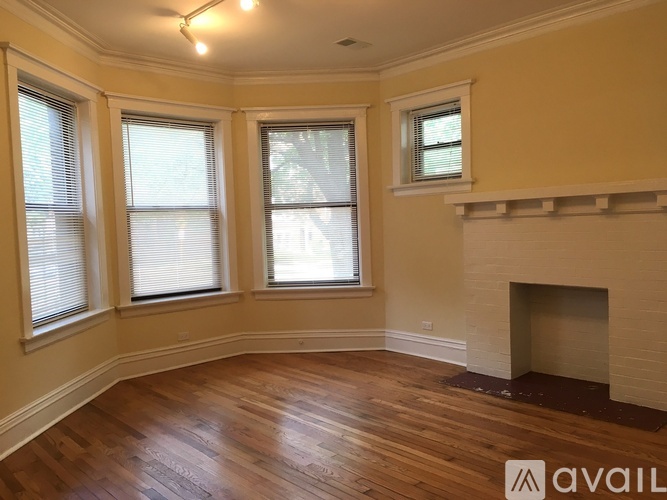 A room with a fireplace and three windows.