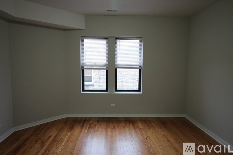 A room with wooden floors and two windows.