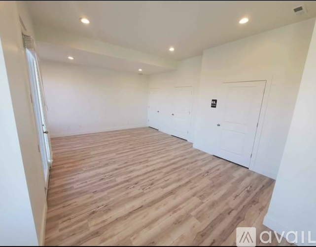 A room with wooden flooring and white walls.