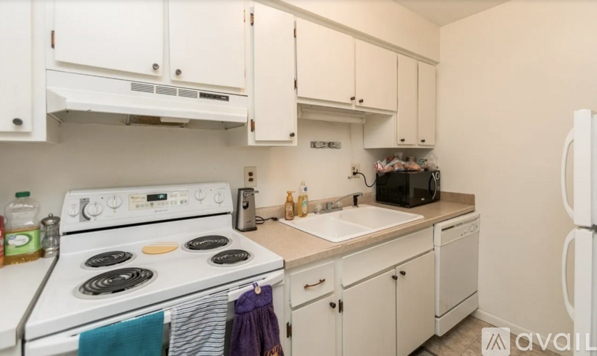 A kitchen with white appliances and cabinets.
