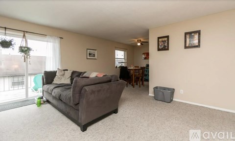 A living room with a grey couch and a green chair.