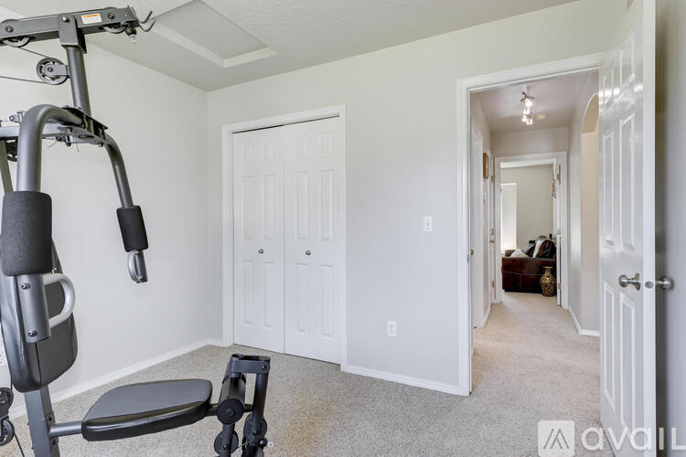 A gym setup in a home with a weight bench and a pull up bar.