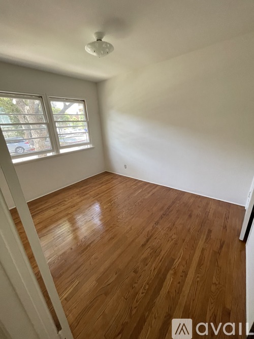 A room with wooden flooring and a window.