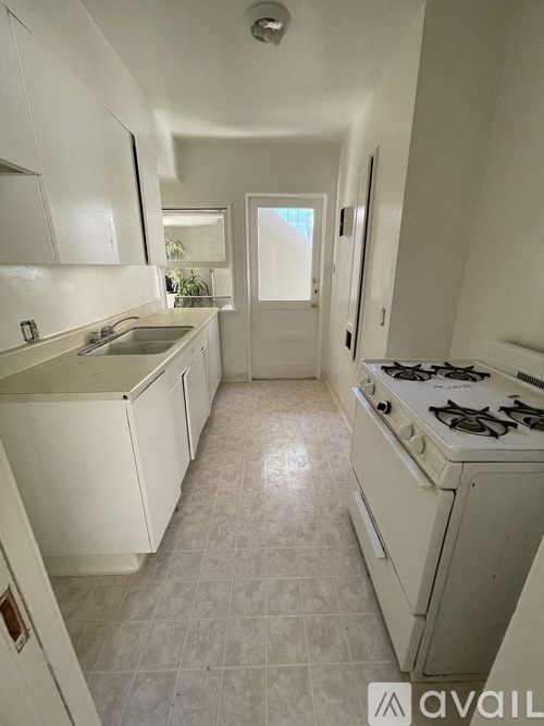A kitchen with white cabinets and a white stove.