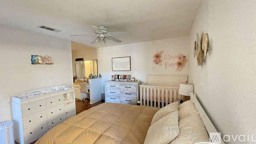 A bedroom with a white bed and a white dresser with a mirror above it.