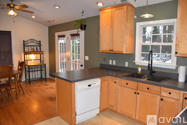 A kitchen with wooden cabinets and a white dishwasher.