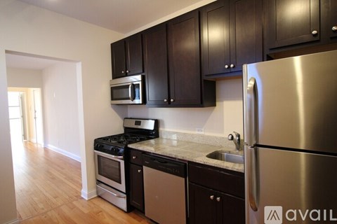 A kitchen with dark wood cabinets and stainless steel appliances.