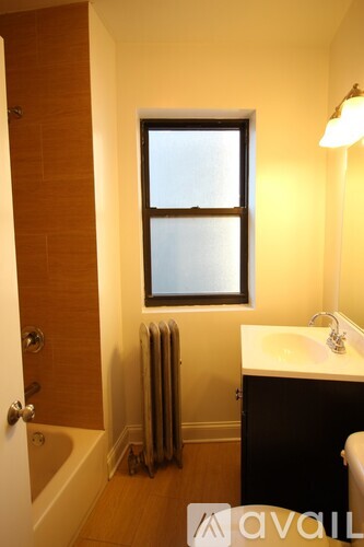 A bathroom with a window, sink, and towel rack.