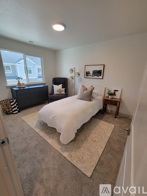 A bedroom with a bed, nightstand, and window.