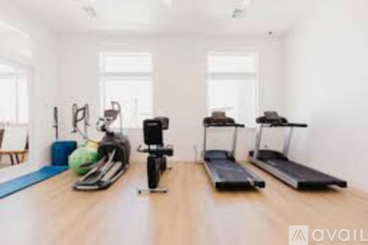 A home gym with a treadmill, exercise bike, and weights.