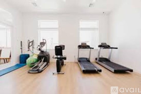 A home gym with a treadmill, exercise bike, and weights.