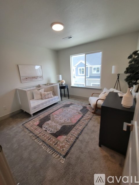 A living room with a rug, a sofa, a chair, and a table.