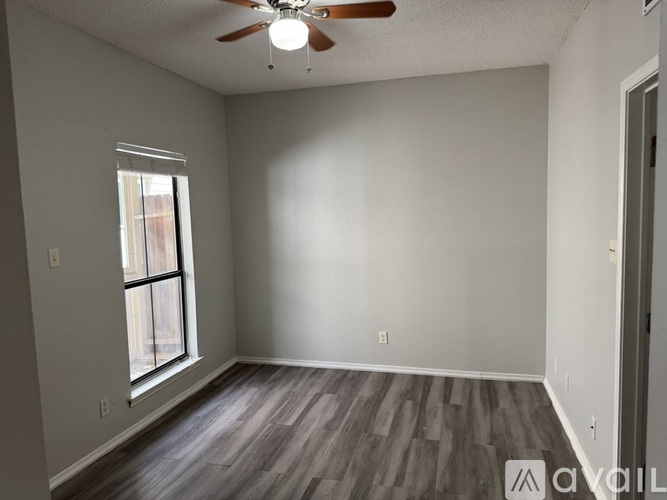A room with a ceiling fan and a window.